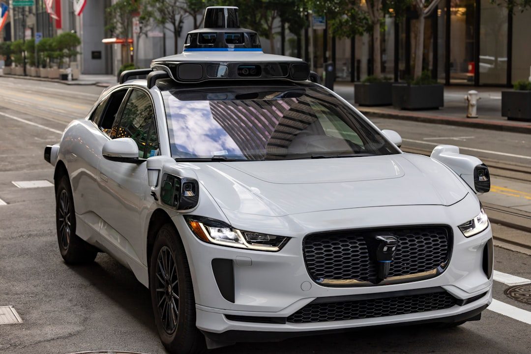 A white self-driving car on a city street.