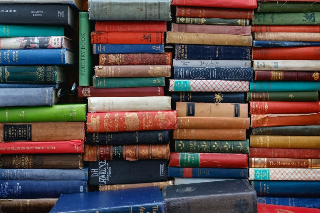Stapel gebundener Bücher in einer ruhigen Bibliothek
