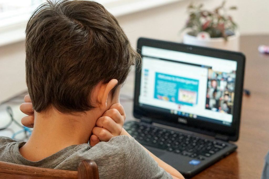 Jugendlicher arbeitet konzentriert an einem Laptop