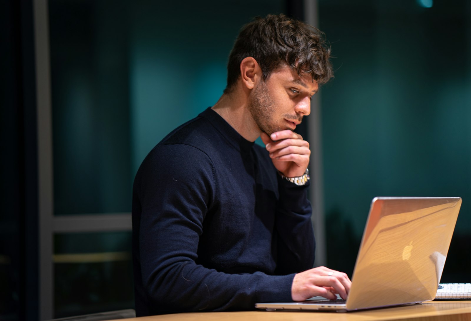 Eine Person überlegt am Laptop
