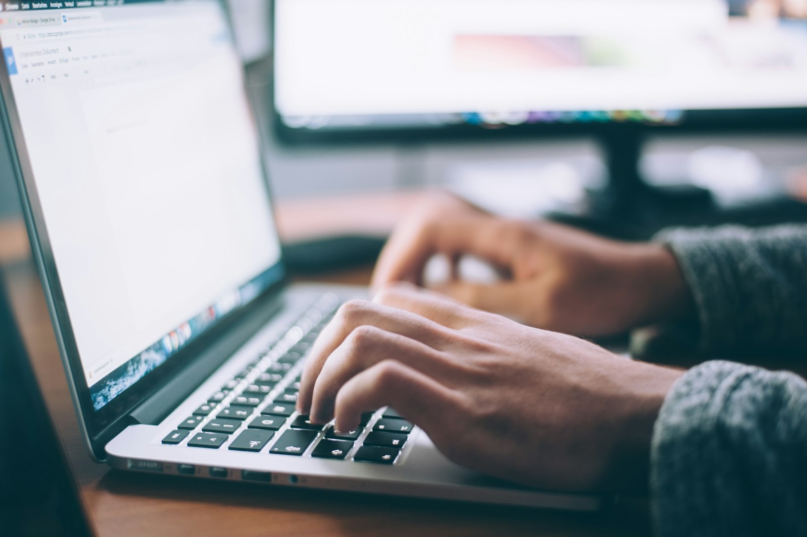 Nahaufnahme einer Person, die auf einer Mac-Tastatur tippt