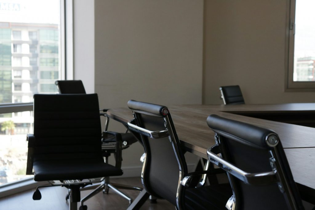 Leerer Konferenzraum mit aufgereihten Stühlen als Sinnbild für personelle Umstrukturierung