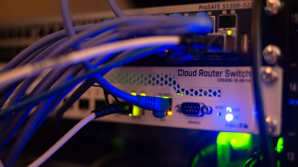 Blick in einen Serverraum mit vielen blau beleuchteten Netzwerkkabeln