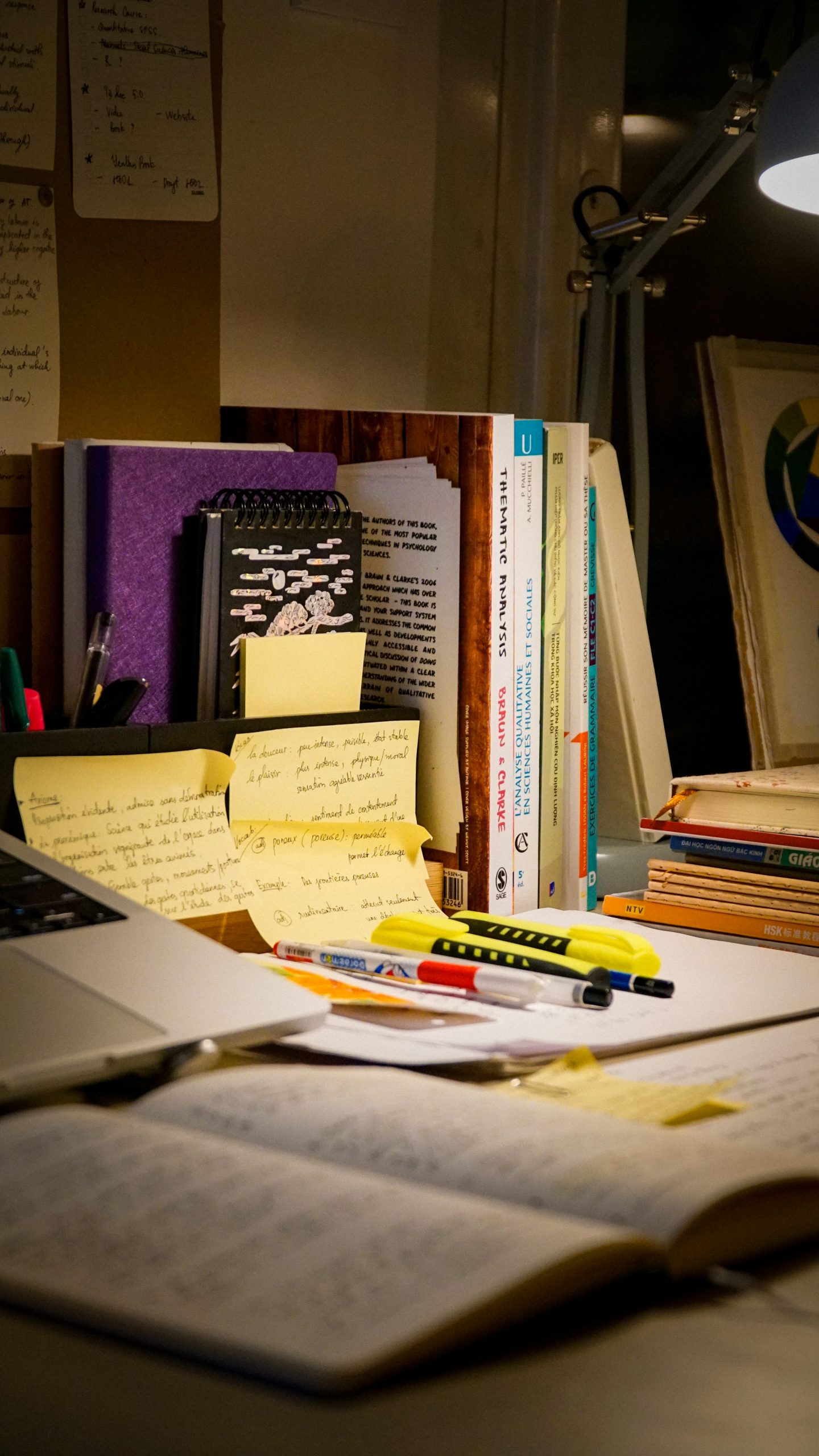 Schreibtisch mit Laptop, Büchern und Notizen als Symbol für das Gedächtnis eines KI-Agenten