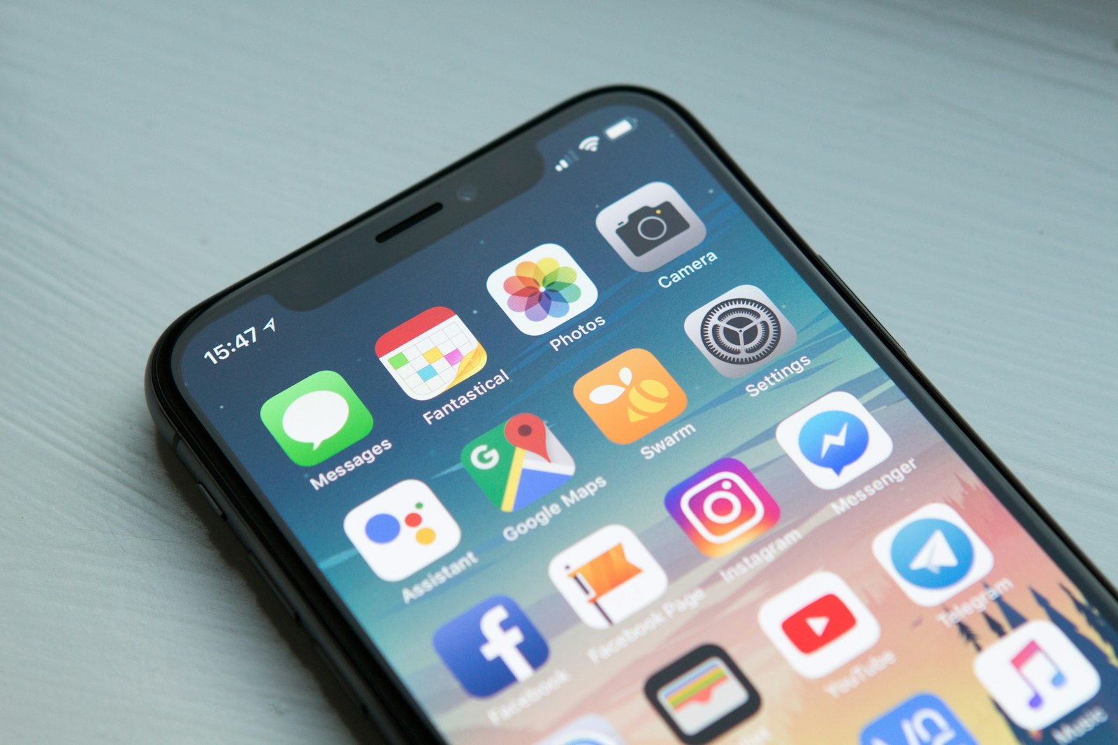 Hand hält ein Smartphone mit geöffneter Chat-App vor unscharfem Hintergrund