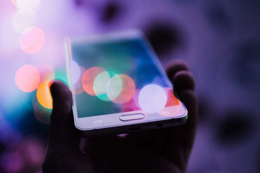 Das Licht eines Smartphone-Bildschirms in einem abgedunkelten Raum bei Nacht