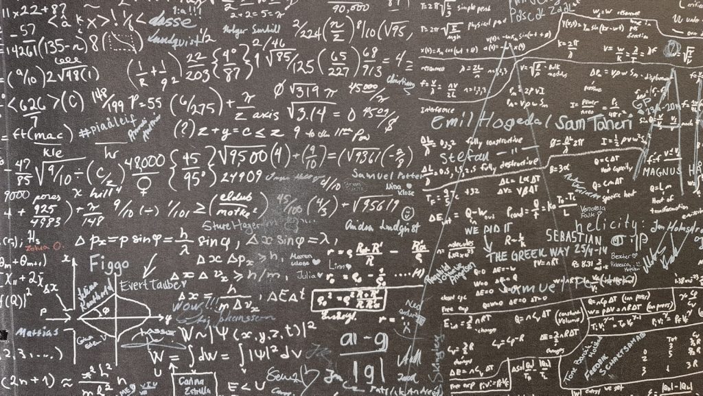 Mathematische Gleichungen in Kreide auf einer dunklen Tafel