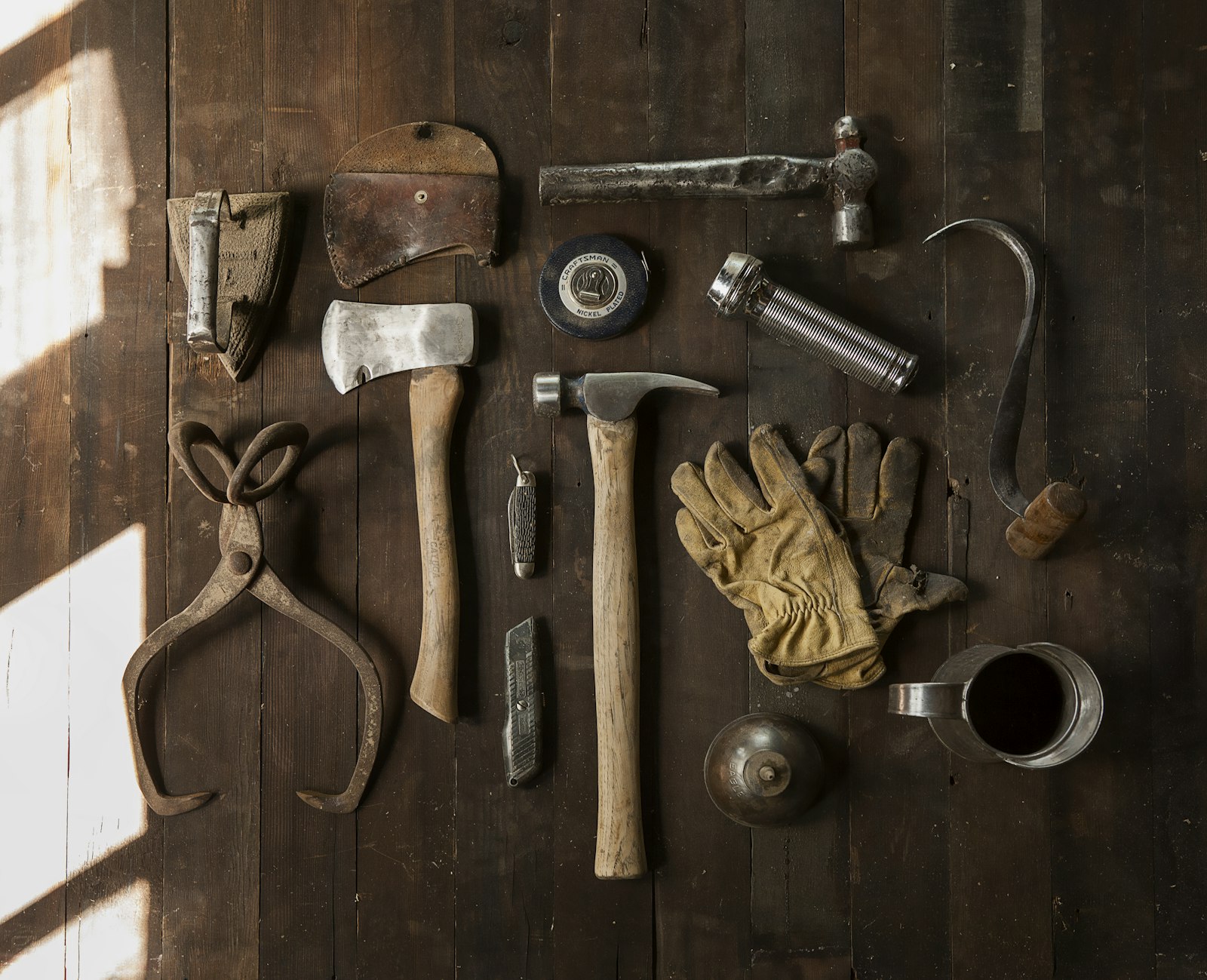 Handwerkzeuge und Arbeitshandschuhe auf einer Holzfläche