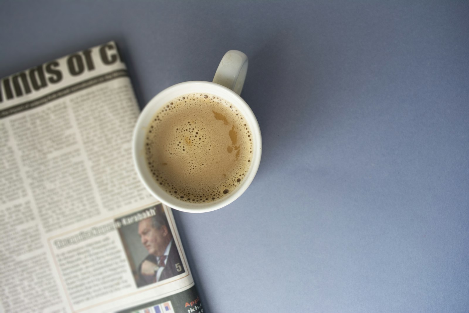 Zeitung und Kaffeetasse auf einem Schreibtisch am Morgen