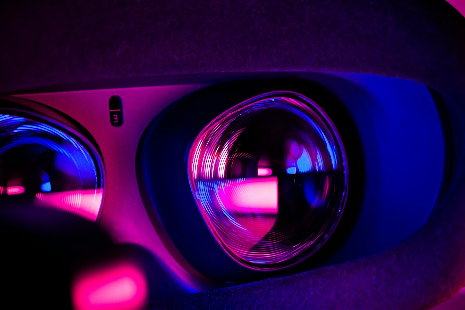 Nahaufnahme der Linsen einer VR-Brille in violettem und blauem Licht
