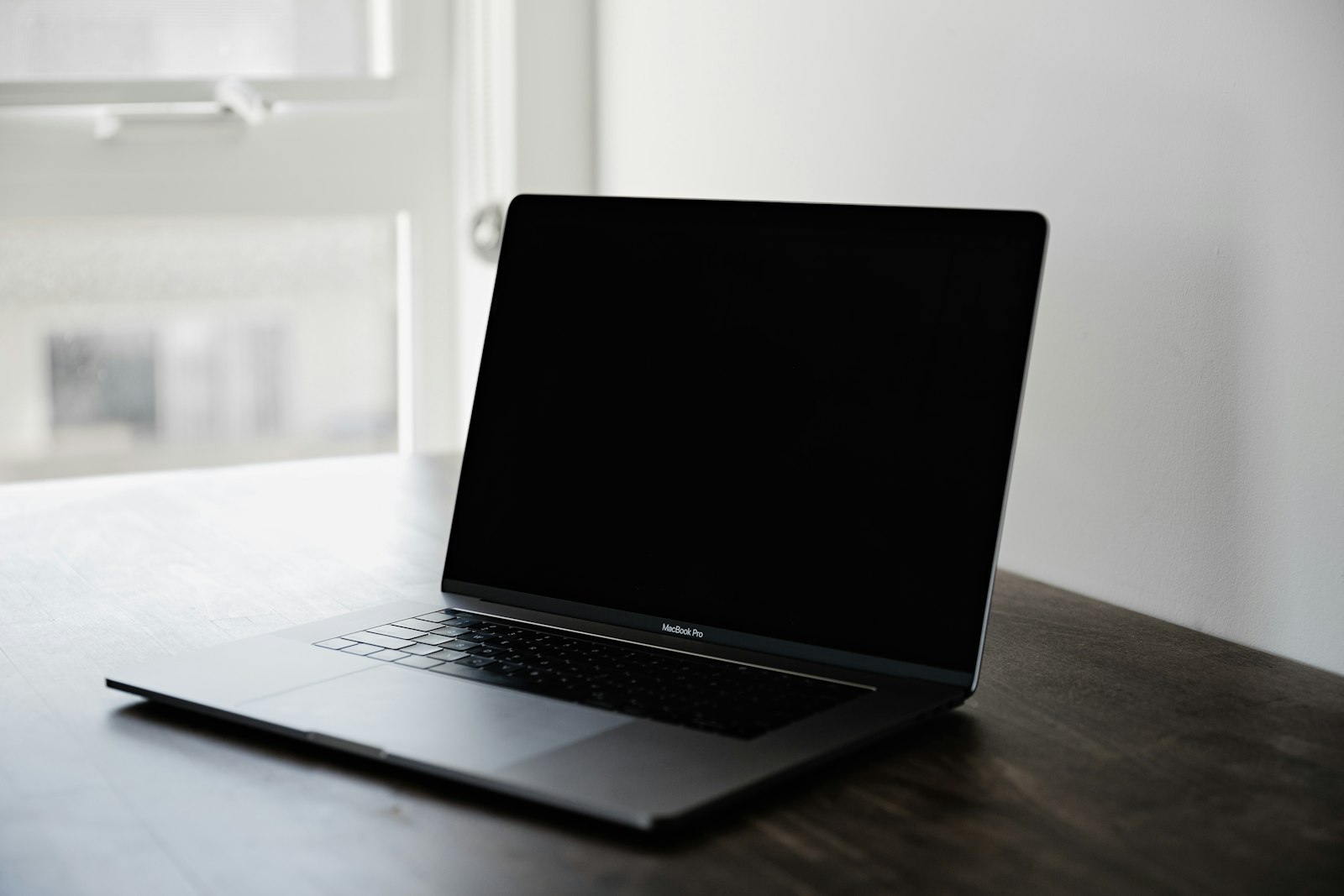 Eine Person prüft am Laptop Textnachrichten in einem Büro, Symbolbild für menschliche Kontrolle von KI-Chats