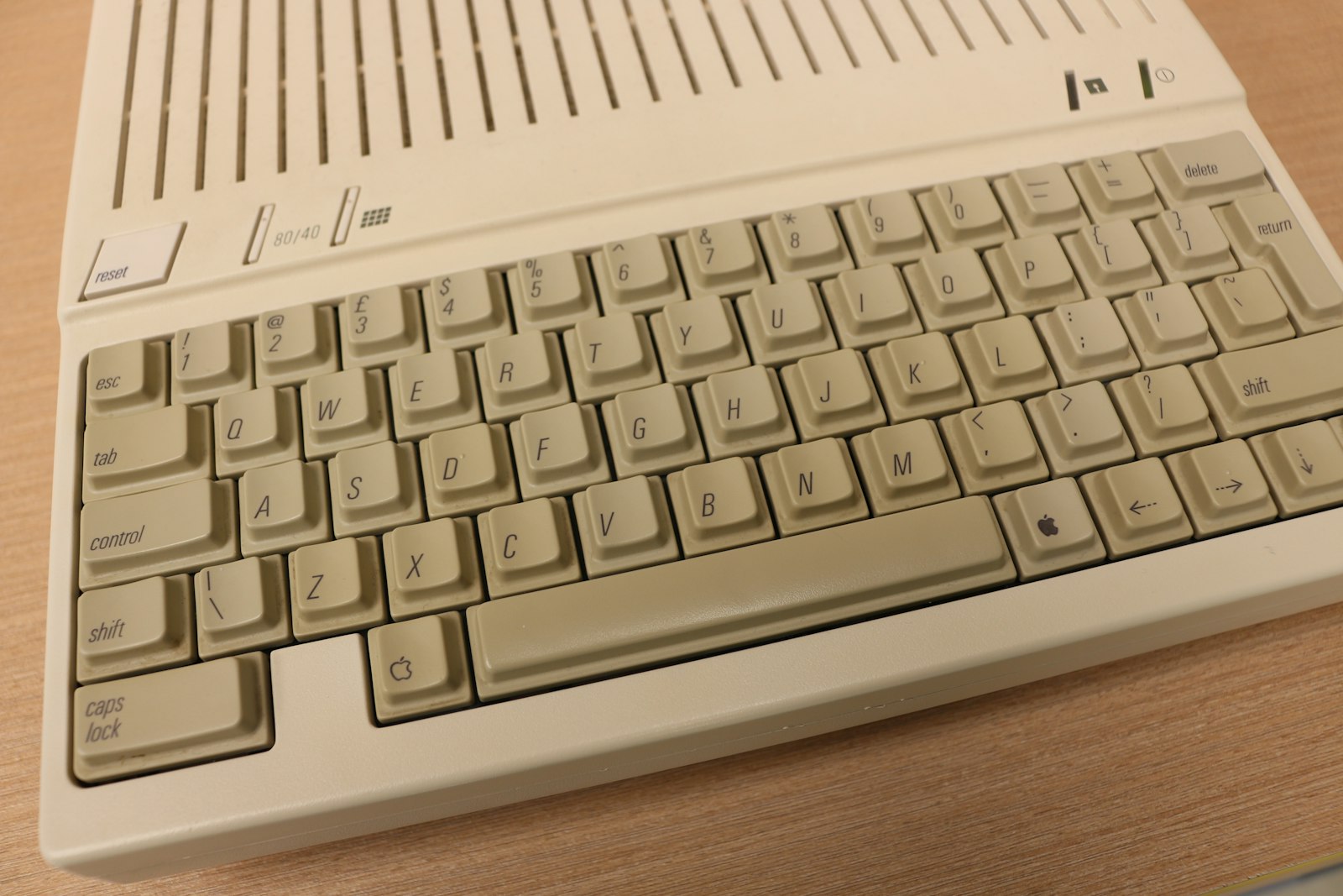 Beige Tastatur eines historischen Computers auf einer Holzfläche