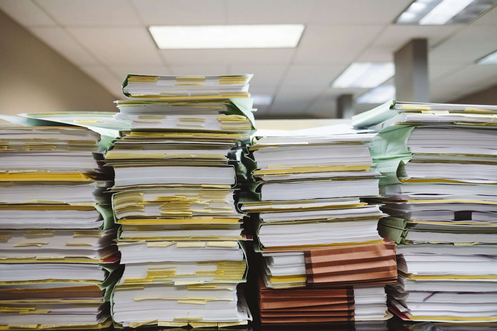 Stapel von Papierakten und Dokumentenmappen in einem Büro