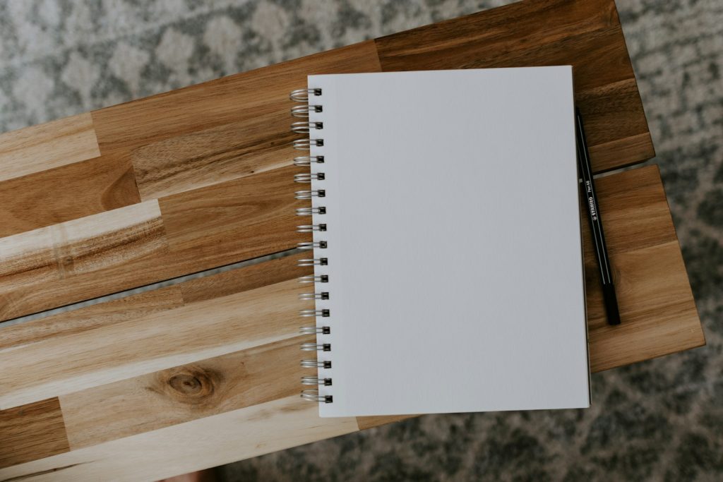Aufgeschlagenes Notizbuch mit handschriftlichen Notizen auf einem Schreibtisch