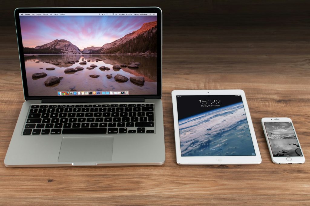 Laptop, Tablet und Smartphone auf einem Holztisch
